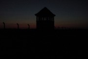 Foto der Frontseite des Konzentrationslagers Auschwitz - Brikenau mit Wachturm der SS bei Nachteinbruch 2005